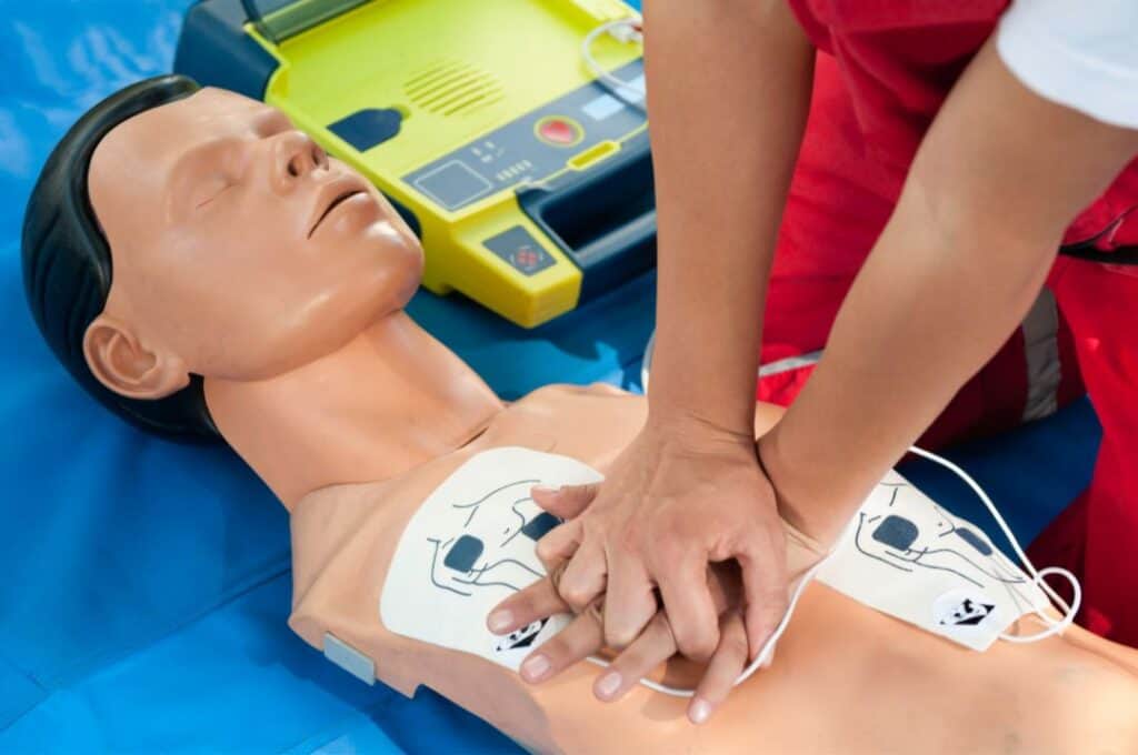 Defibrillator pad on chest of manakin defibrillaator in background