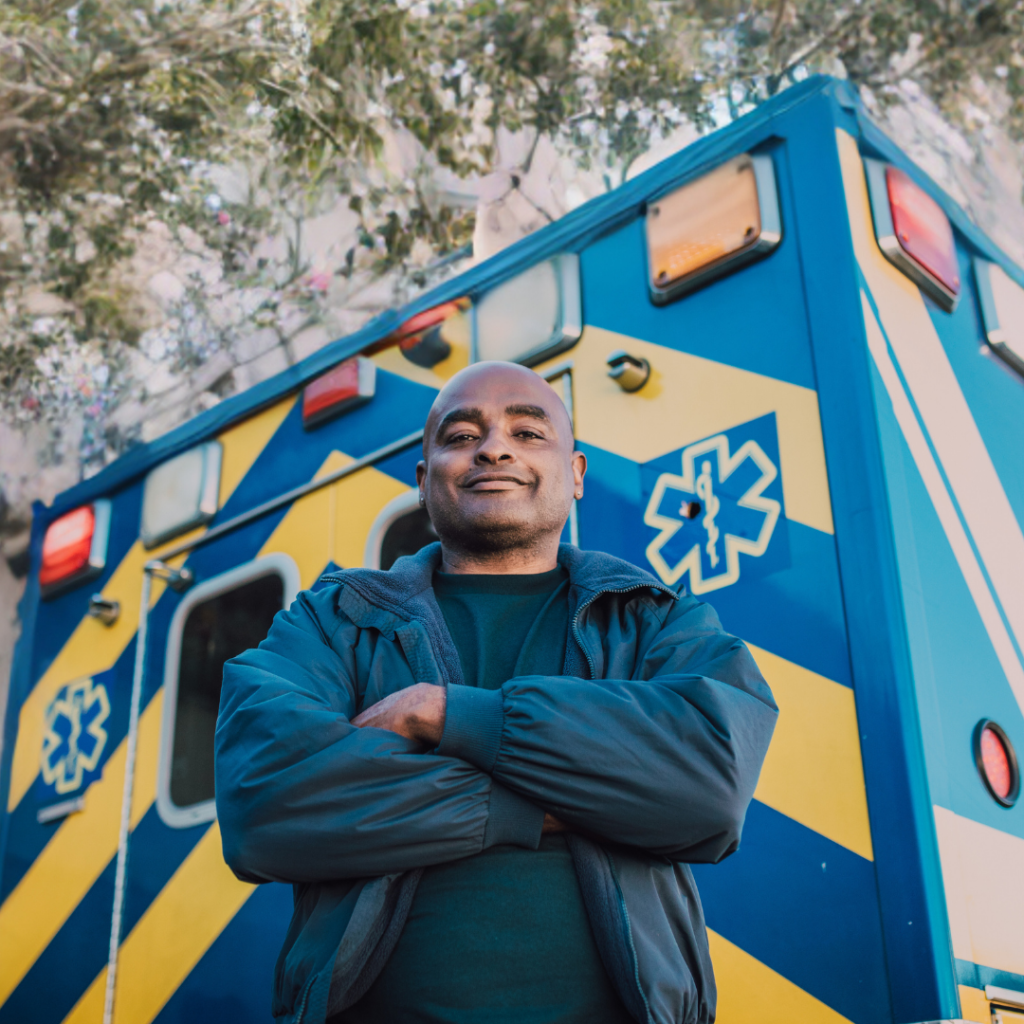 an ambulance driver stands in front of his vehicle