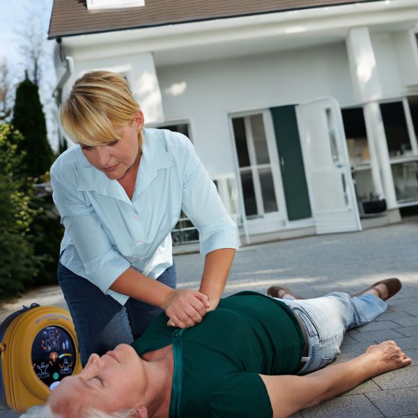 a woman uses a defibrillator at home